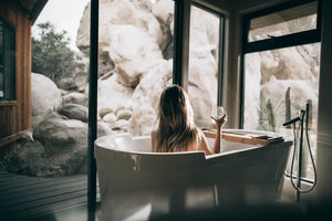 Women drinking alcohol free wine in bathtub